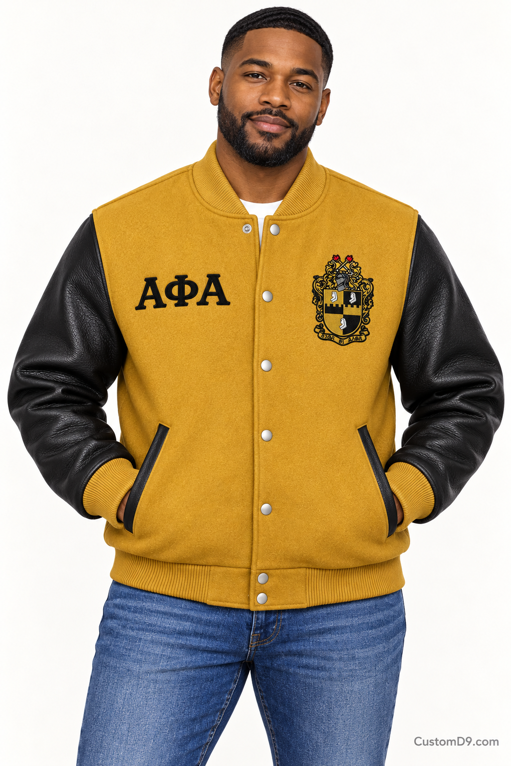 Black man modeling Alpha Phi Alpha premium contrast varsity jacket with old gold body and black sleeves, front view.
