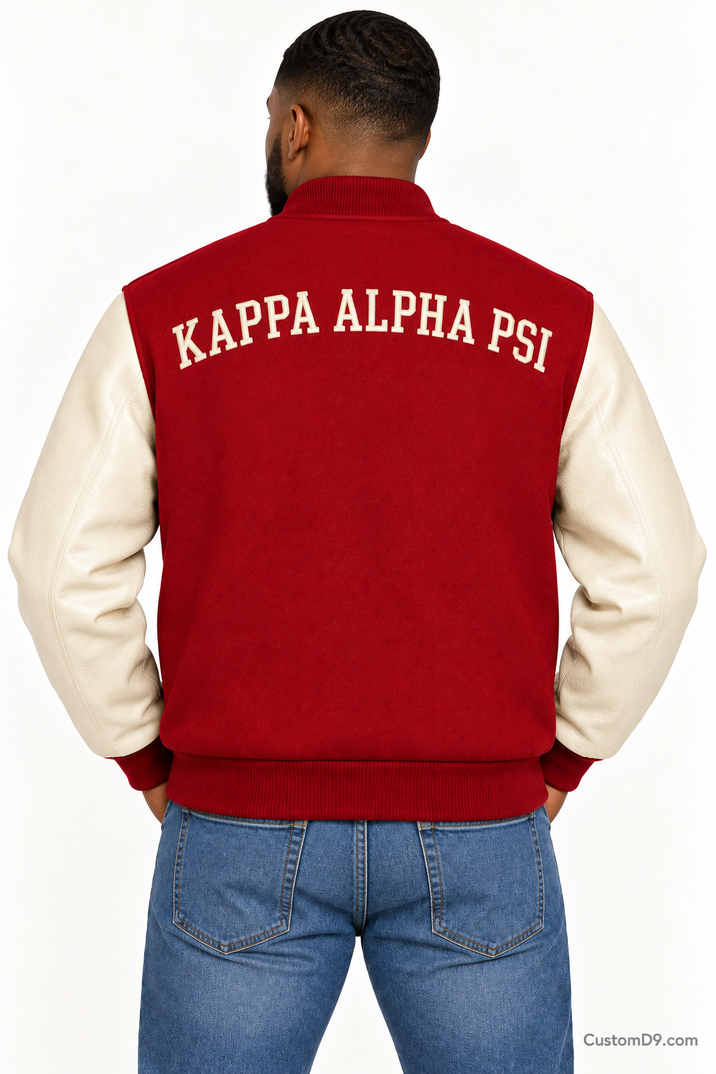 Black man modeling Kappa Alpha Psi premium contrast varsity jacket with crimson body and cream sleeves, back view.