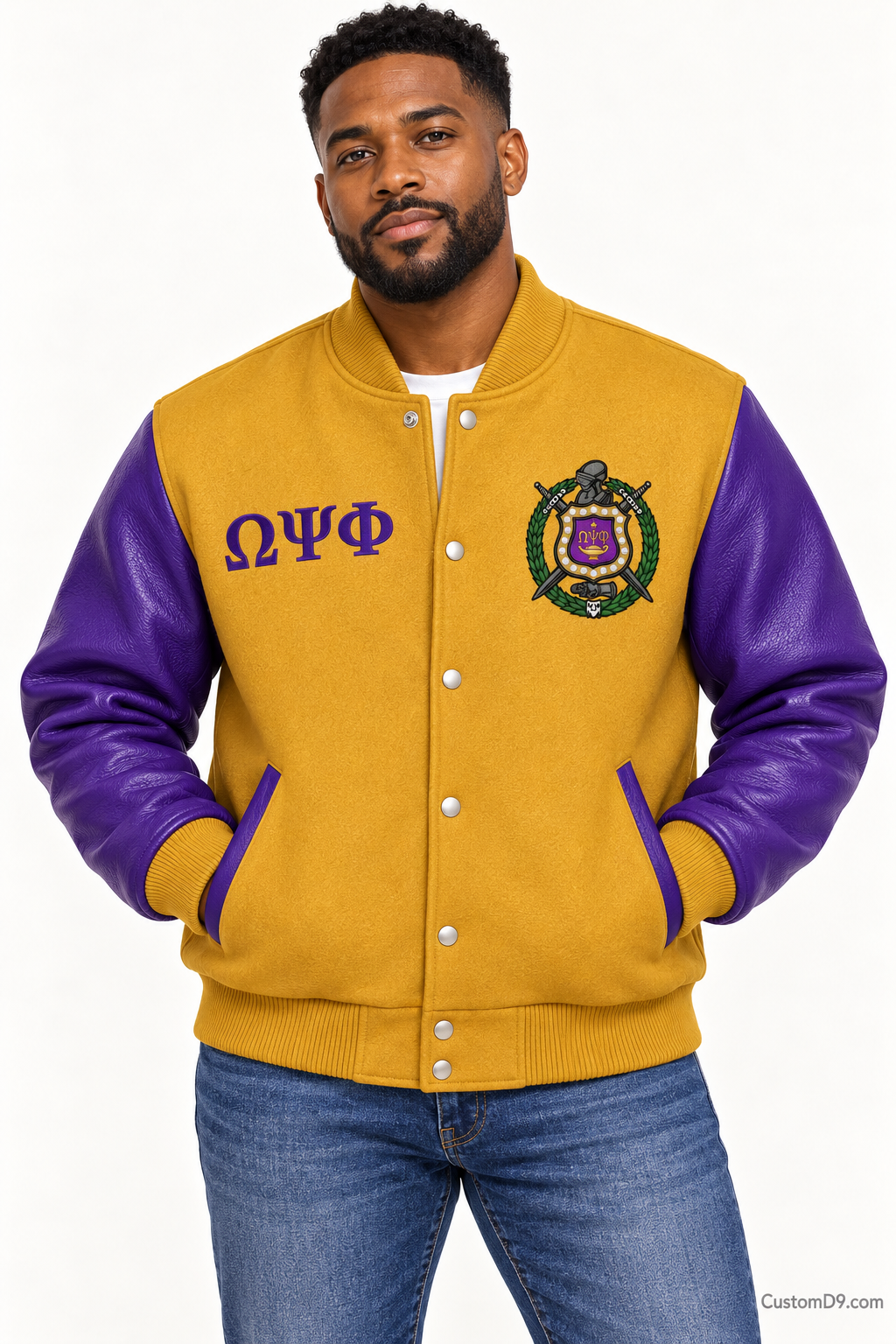Black man modeling Omega Psi Phi premium contrast varsity jacket with old gold body and royal purple sleeves, front view.