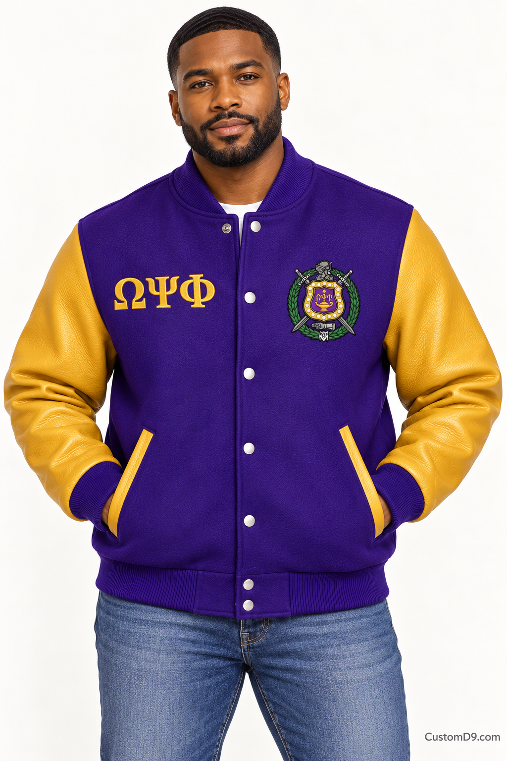 Black man modeling Omega Psi Phi premium contrast varsity jacket with royal purple body and old gold sleeves, front view.