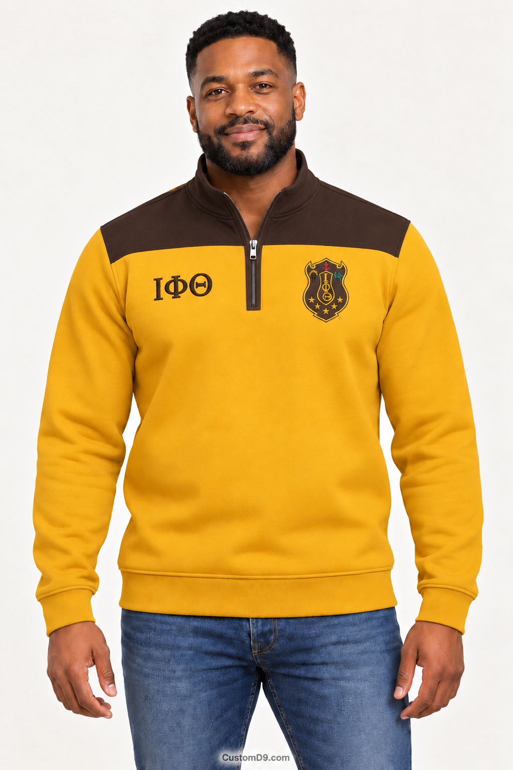 Black male model showing front of Iota Phi Theta gilded gold quarter-zip with charcoal brown shoulder panel