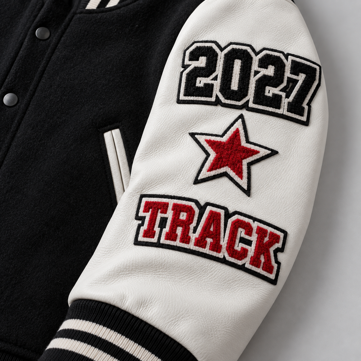 Letterman jacket sleeve with graduation year star and track patches
